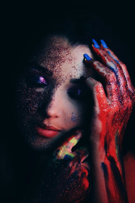 a woman with paint on her face and hands, an album cover, inspired by Elsa Bleda, trending on pexels, red blue purple black fade, dark glitter, alien girl, professional body paint