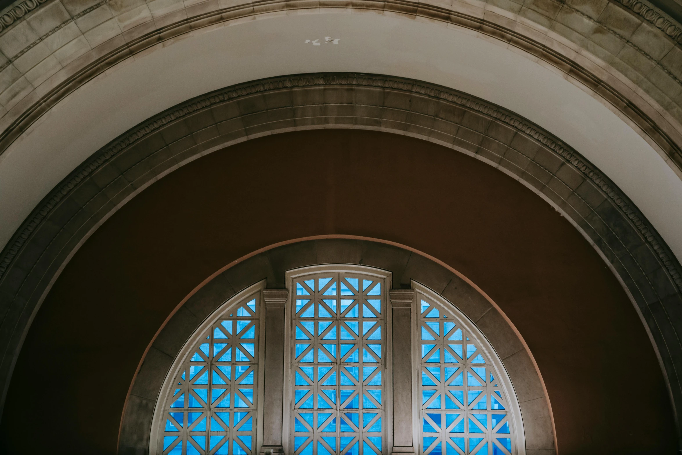 a couple of people that are standing in front of a window, by Carey Morris, unsplash contest winner, art nouveau, high arched ceiling, washington dc, brown and cyan blue color scheme, train window