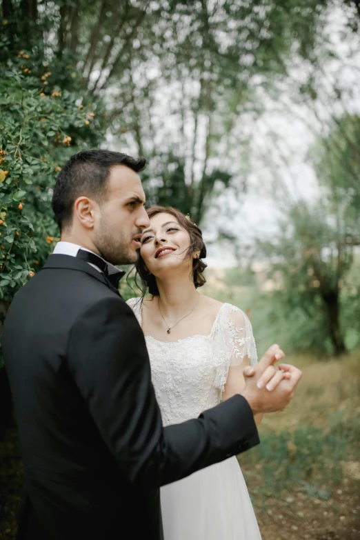 a man in a tuxedo standing next to a woman in a wedding dress, a picture, pexels contest winner, renaissance, trees in the background, touching heads, gif, caucasian