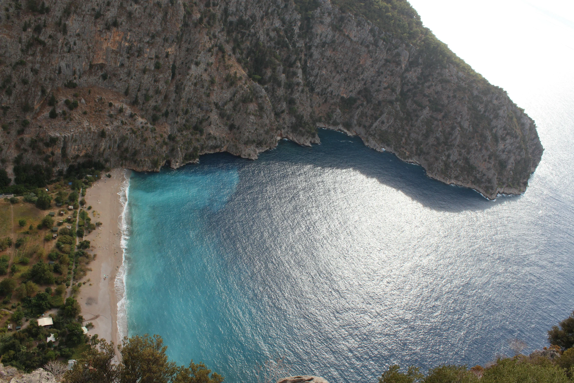 a large body of water next to a cliff, pexels contest winner, hurufiyya, white beaches, avatar image, turkey, close-up from above