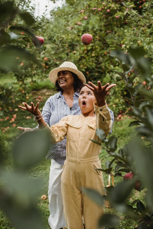 a woman and a child standing in an apple orchard, pexels contest winner, renaissance, shocked expression on her face, waving, chief keef in the garden of eden, wearing a straw hat and overalls