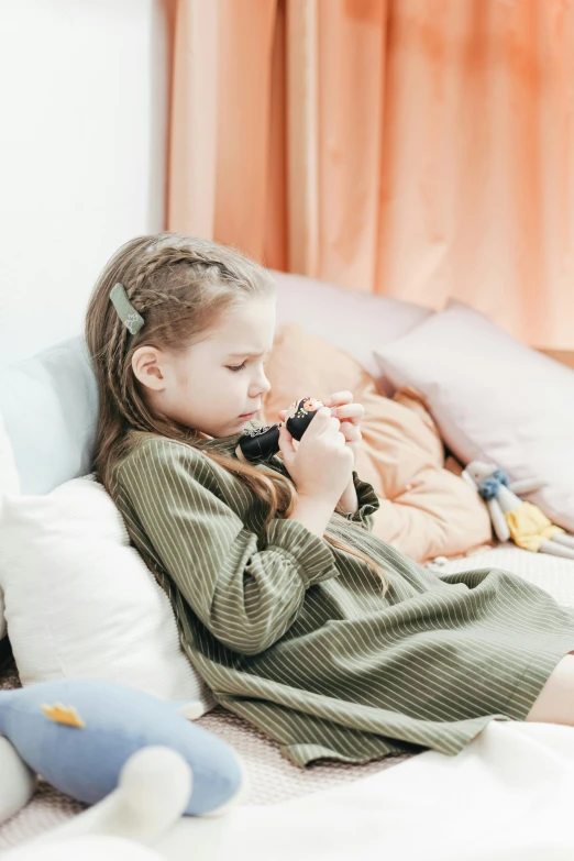 a little girl laying on a bed with a stuffed animal, a picture, by Adam Marczyński, pexels, holding a blaster, checking her cell phone, at the sitting couch, full body profile camera shot