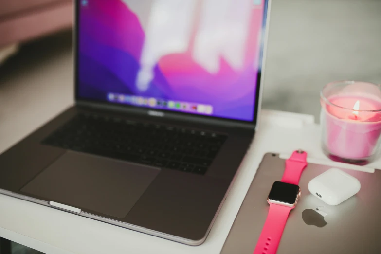 a laptop computer sitting on top of a white table, by Robbie Trevino, trending on pexels, neon pink, apple, jewelry, from waist up