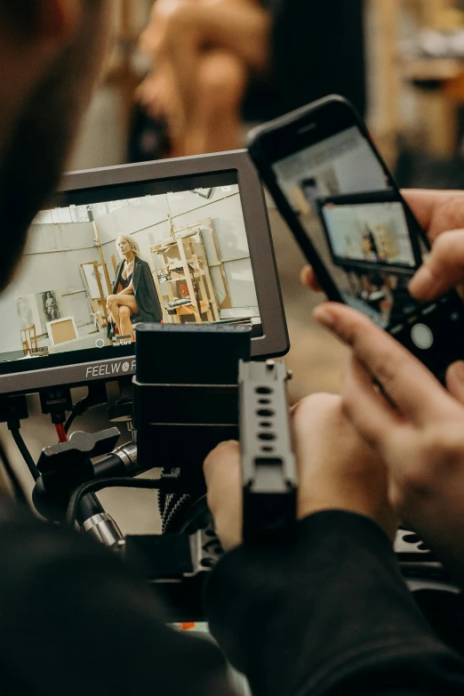 a close up of a person holding a cell phone, a picture, video art, on set, hasselblad photo, tv footage, rear-shot