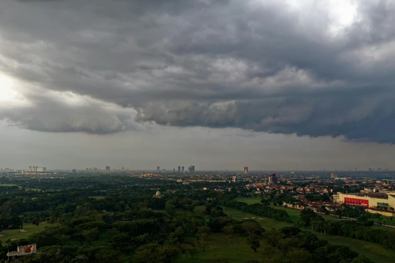 a view of a city from the top of a hill, by Basuki Abdullah, thunderstorm, unmistakably kenyan, ultrawide landscape, south jakarta