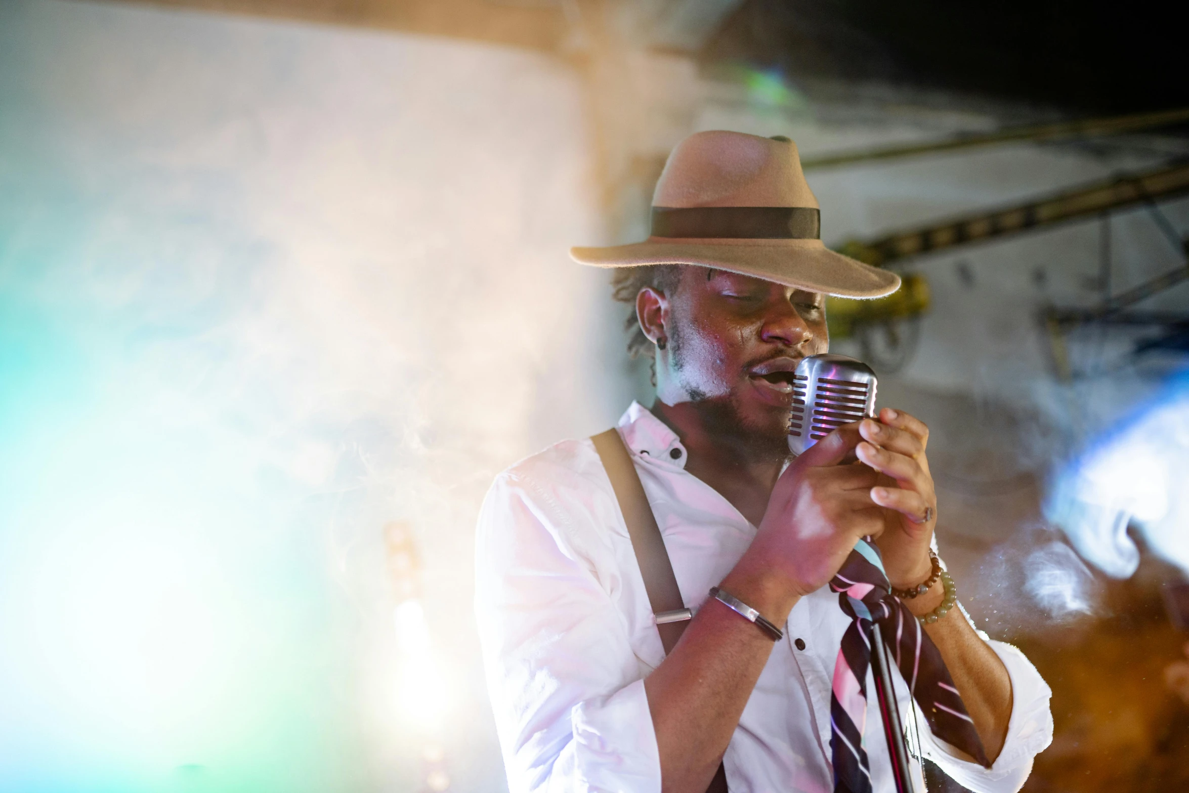 a man in a fedora singing into a microphone, by Daniel Lieske, pexels, jamaica, multiple stories, : kendrick lamar, drinking