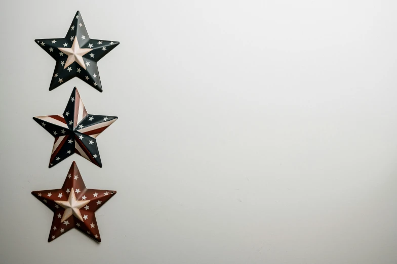 three red, white and blue stars hanging on a wall, an album cover, by Carey Morris, pexels, background image, profile image, black stars, slight overcast