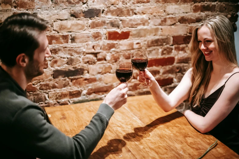 a man and a woman sitting at a table holding wine glasses, pexels contest winner, heath clifford, 1 5 0 4, reaching out to each other, girls