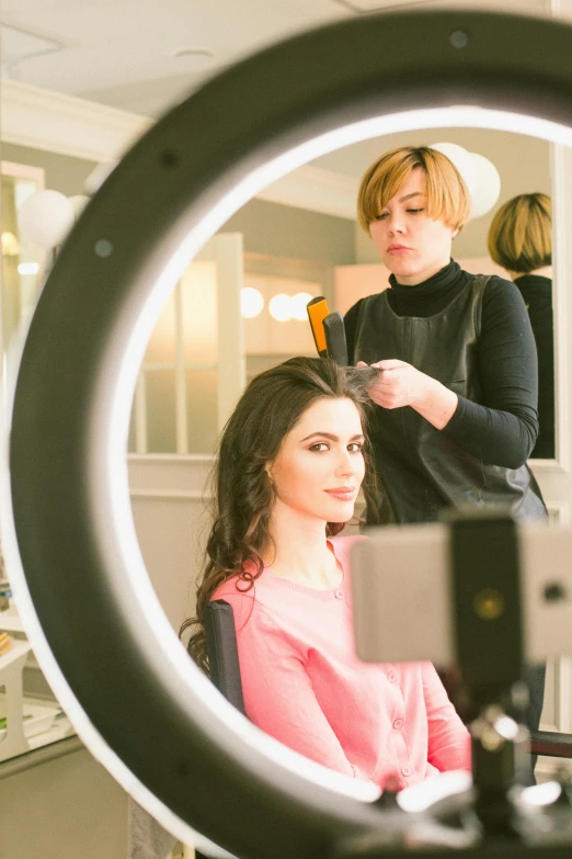 a woman getting her hair done in front of a mirror, ring light, professional profile picture, uploaded, brunette