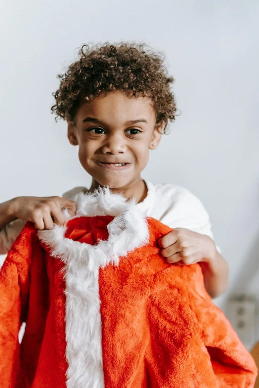 a little boy dressed up as santa claus, pexels contest winner, happening, blue'snappy gifts'plush doll, large cape, with afro, cute young man