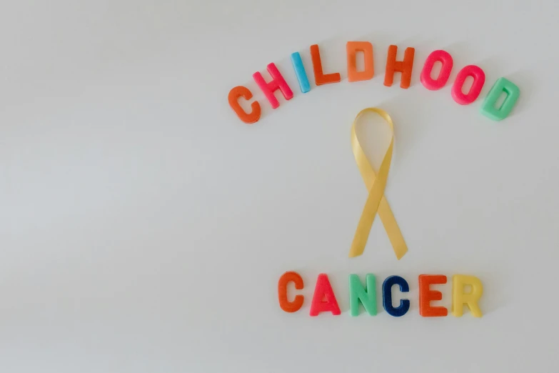 a sign that says childhood cancer with a yellow ribbon, pexels contest winner, 🚀🌈🤩, 90's photo, 10k, 2045