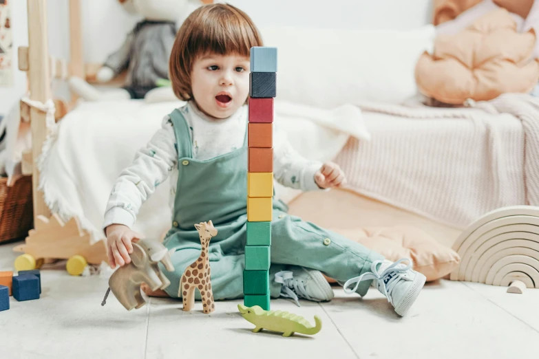 a little girl sitting on the floor playing with blocks, by Emma Andijewska, pexels contest winner, towering above a small person, organic growth, grey, scientific