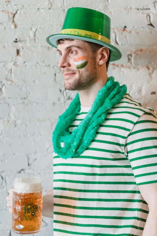 a man in a green hat holding a glass of beer, pexels contest winner, wearing stripe shirt, ruffles, man wearing a closed cowl, irish