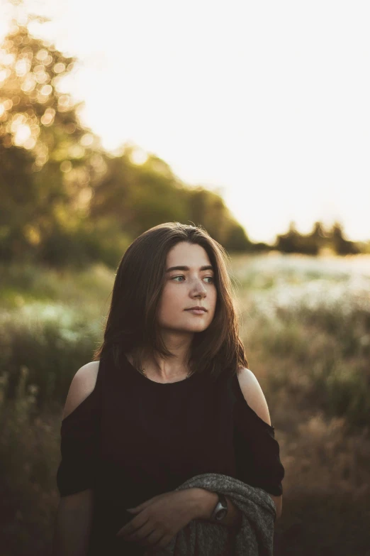 a woman standing in the middle of a field, girl with dark brown hair, with backdrop of natural light, ((portrait)), instagram picture