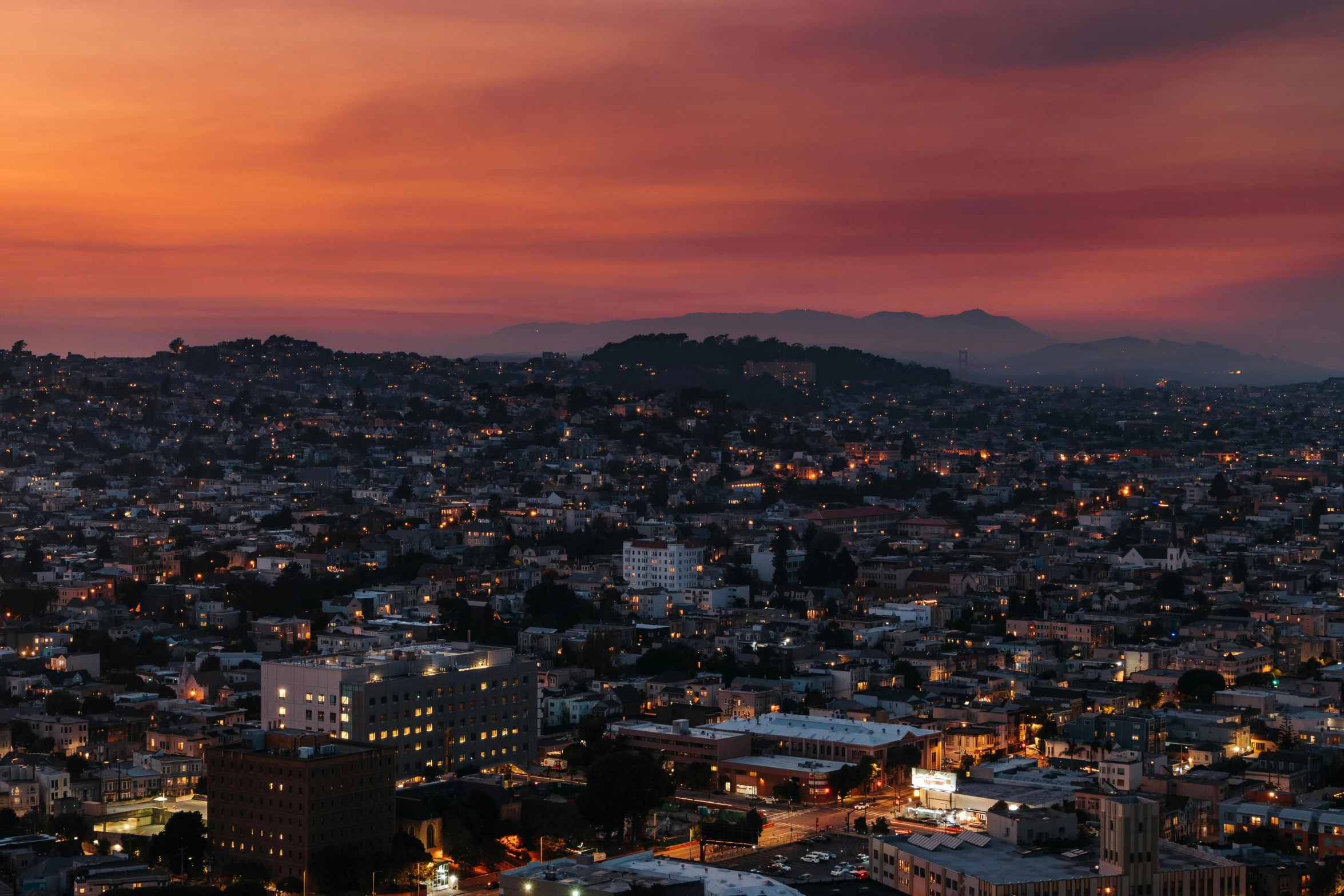 a view of a city from the top of a hill, by Carey Morris, unsplash contest winner, renaissance, orange lit sky, westside, calarts, red hues