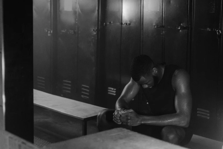 a black and white photo of a man sitting in a locker, pexels, athletic muscle tone, man is with black skin, tears running down, athletic footage