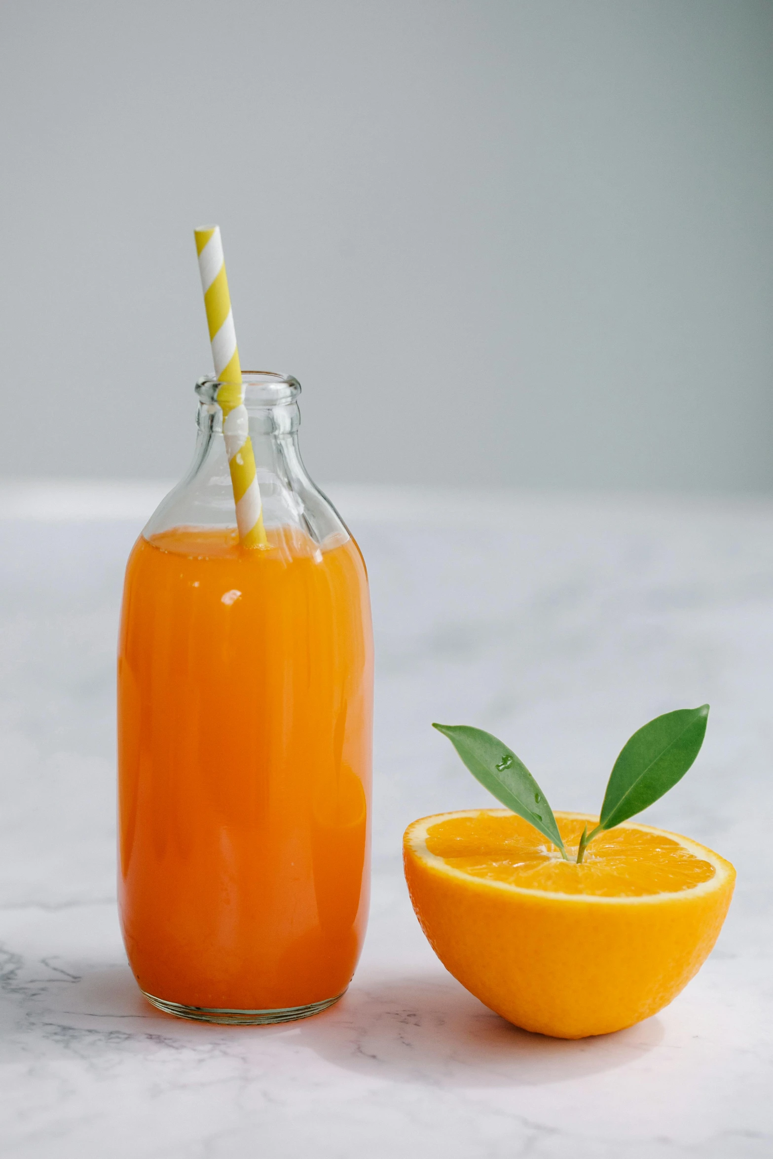 a bottle of orange juice next to an orange slice, profile image