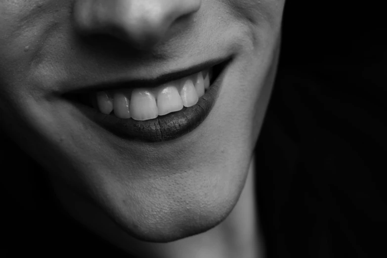 a close up of a person with a tooth brush in their mouth, a black and white photo, by Kristian Zahrtmann, pixabay, smiling :: attractive, androgynous face, square masculine jaw, joker smile