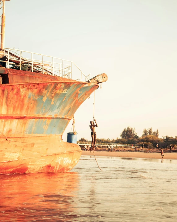 a rusty boat sitting on top of a body of water, hanging, red sand, wearing dirty travelling clothes, instagram photo