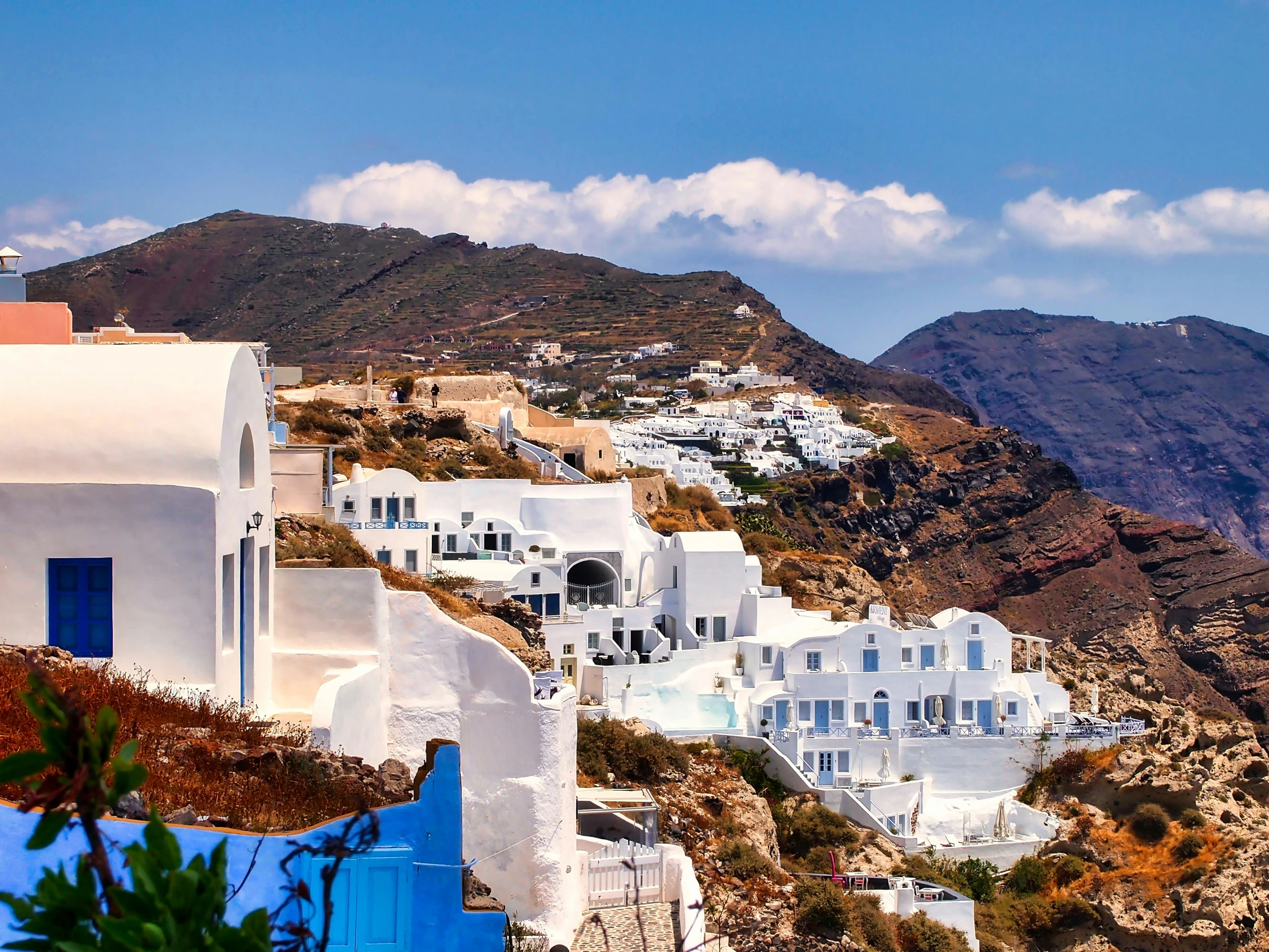 a blue and white building with a mountain in the background, pexels contest winner, neoclassicism, white houses, hills and ocean, white lava, bandoliers