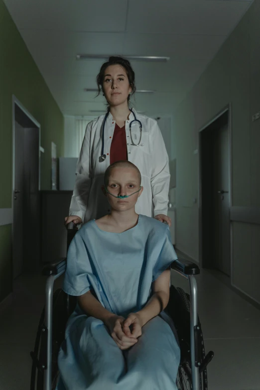 a woman standing next to a man in a wheelchair, a portrait, by Adam Marczyński, promotional still wide angle, surgeon, portrait of bald, ( ( theatrical ) )