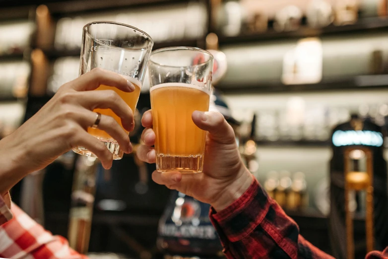 two people clinking glasses of beer at a bar, by Carey Morris, pexels, 🦩🪐🐞👩🏻🦳, local heroes, aussie baristas, suddenly there came a tapping