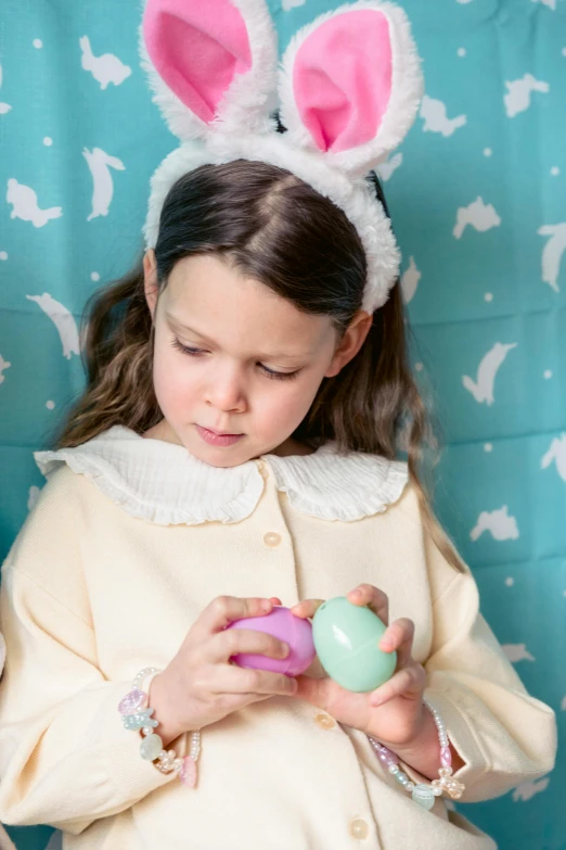 two little girls wearing bunny ears and holding easter eggs, a portrait, inspired by Elsa Beskow, pexels, pastel colours overlap, pensive wizard examining eggs, wearing a nightgown, softplay