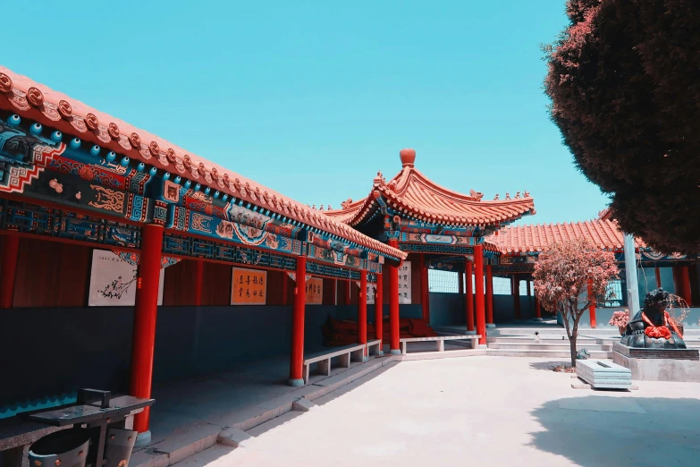 a red and blue building with a bench in front of it, inspired by An Zhengwen, pexels contest winner, cloisonnism, colonnade, red lanterns, teal aesthetic, an altar of a temple