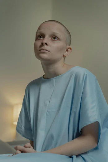 a man in a hospital gown sitting on a bed, by Anna Füssli, trending on reddit, hyperrealism, portrait of 1 5 - year - old boy, juno promotional image, partially bald, color footage