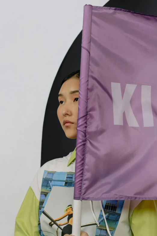 a woman holding a purple flag in front of a white wall, inspired by Kim Tschang Yeul, kitsch movement, hologram sci - fi hood, hibernation capsule close-up, kiko mizuhara, cloth banners