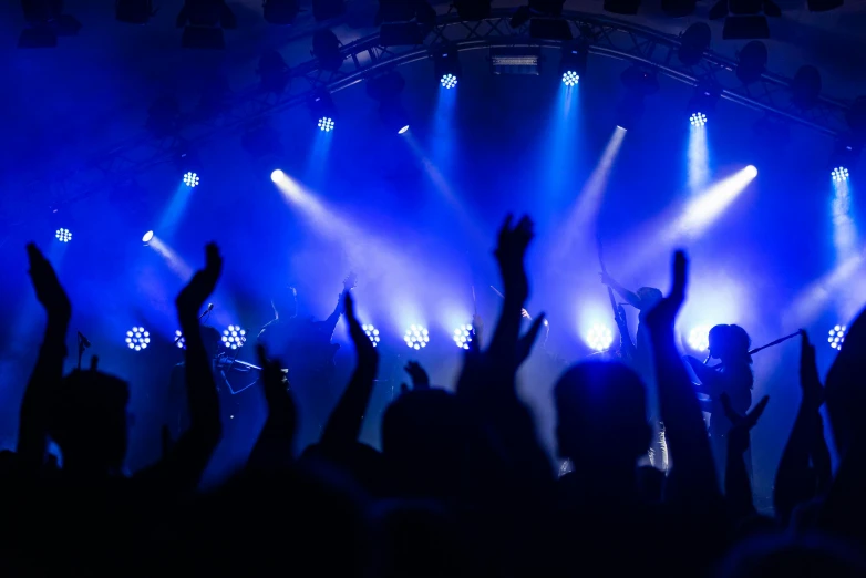 a crowd of people at a concert with their hands in the air, pexels, dramatic white and blue lighting, thumbnail, clubs, plain background