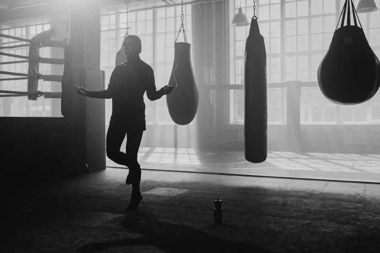 a black and white photo of a man in a boxing ring, pexels contest winner, light and space, woman silhouette, working out, standing on two legs, instagram post