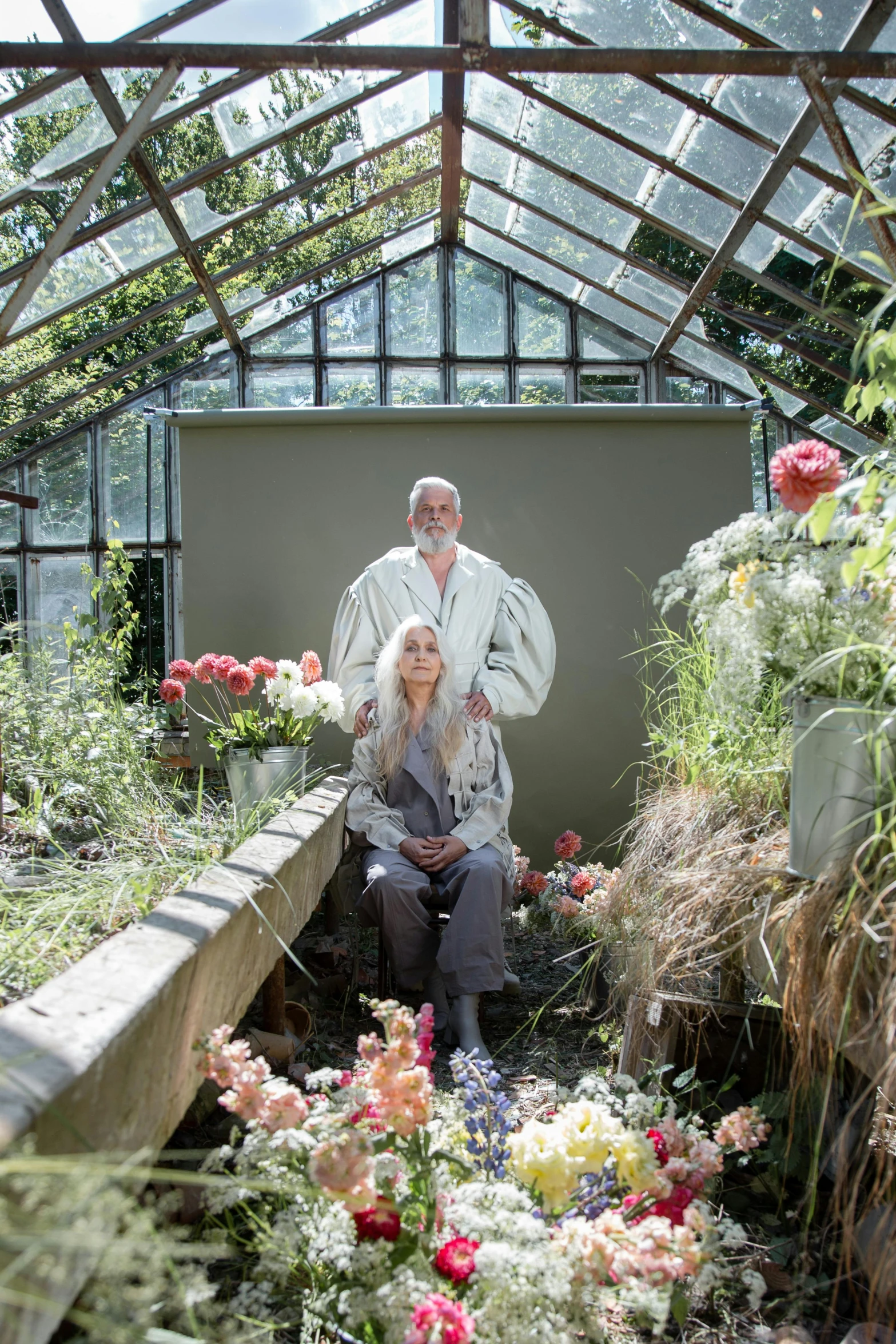 a man and a woman sitting in a greenhouse, a portrait, by Dan Frazier, renaissance, very long silver beard, dirty linen robes, julia hetta, overgrown with puffy orchids