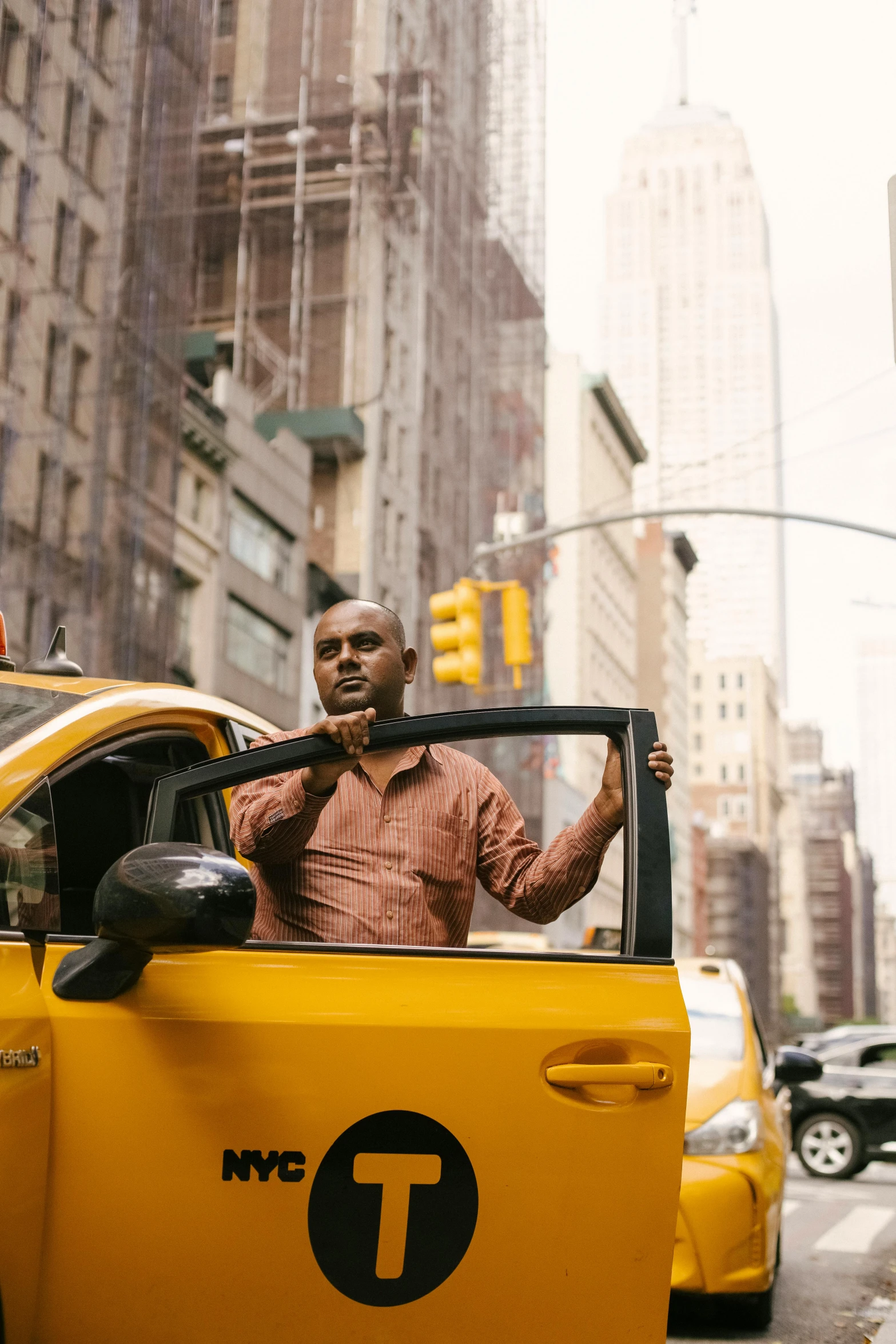 a man sitting in the driver's seat of a taxi, pexels contest winner, happening, standing on street corner, harlem, yellow hue, promotional image