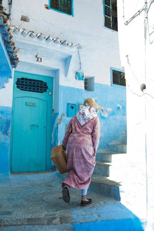 a woman walking up the steps of a blue and white building, mazarineee, lots blue colours, carrying a saddle bag, slide show