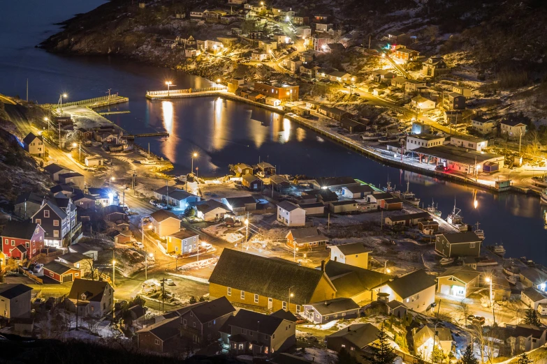 a town lit up at night next to a body of water, happening, small port village, gauthier leblanc, victorian harbour night, thumbnail