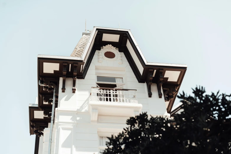 a clock that is on the side of a building, inspired by Sydney Prior Hall, unsplash, art nouveau, beachfront mansion, white and black color palette, view from ground, disneyland