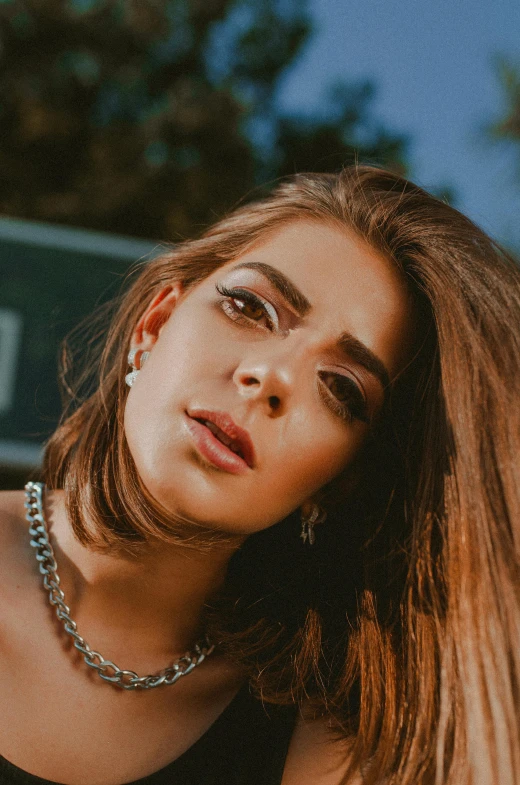 a woman with long hair posing for a picture, an album cover, inspired by Elsa Bleda, trending on pexels, big bold thick eyebrows, jewelry, greek ameera al taweel, teenage girl