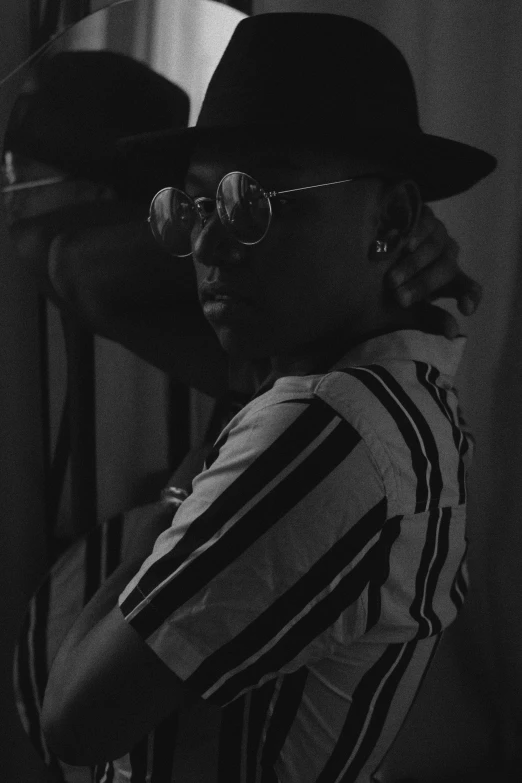 a black and white photo of a man in a hat, by Sergio Burzi, afrofuturism, cowboy hat and glasses, xxxtentacion, mid night, key still