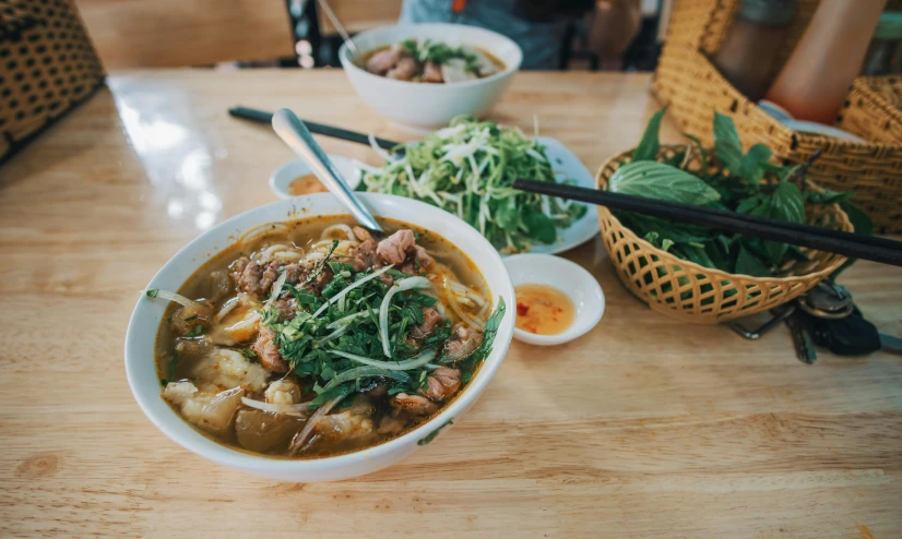 a bowl of soup sitting on top of a wooden table, inspired by Tan Ting-pho, pexels contest winner, people outside eating meals, kete butcher, square, tamborine