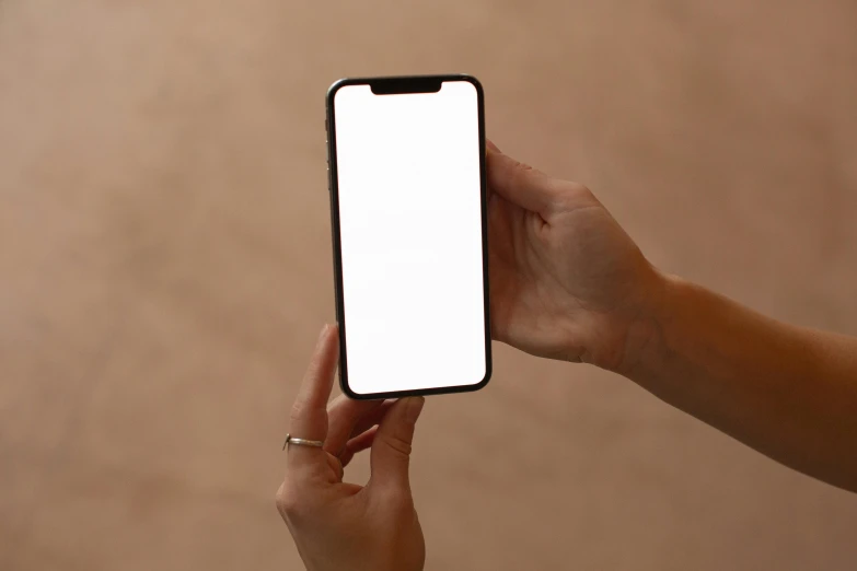 a person holding a cell phone with a white screen, by Carey Morris, trending on pexels, brown, non-illuminated backdrop, rounded corners, glossy white metal