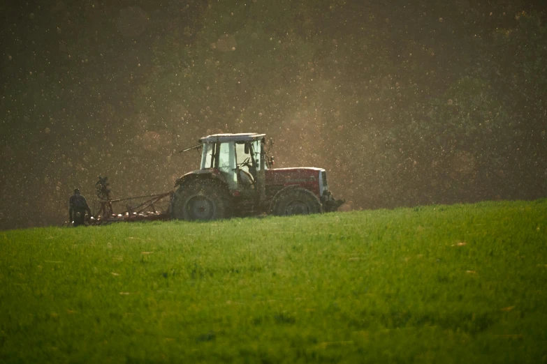 a tractor that is sitting in the grass, a picture, by Eglon van der Neer, spraying liquid, harsh light, raw file, organics