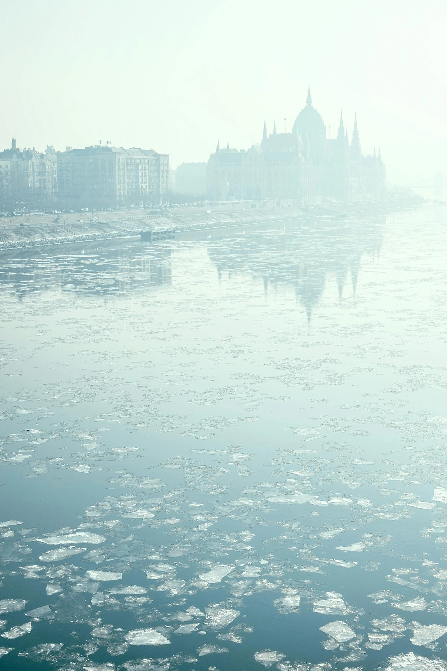 a large body of water with ice floating in it, a matte painting, inspired by Mihály Munkácsy, unsplash contest winner, budapest, ground haze, parliament, polluted