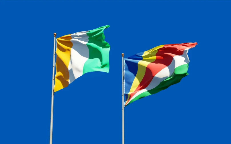 two flags blowing in the wind against a blue sky, inspired by Évariste Vital Luminais, yellow and green, chad, multicoloured, thumbnail