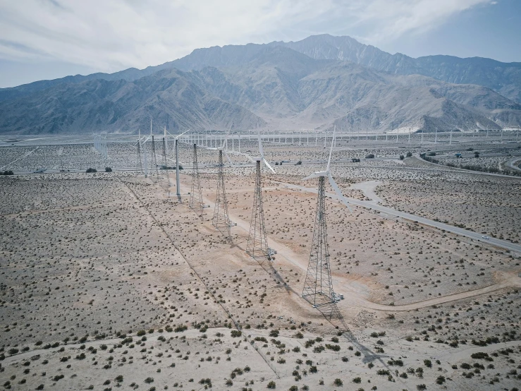 power lines in the desert with mountains in the background, by William Berra, unsplash contest winner, renaissance, megastructures, aerial shot from the drone, moody : : wes anderson, a park