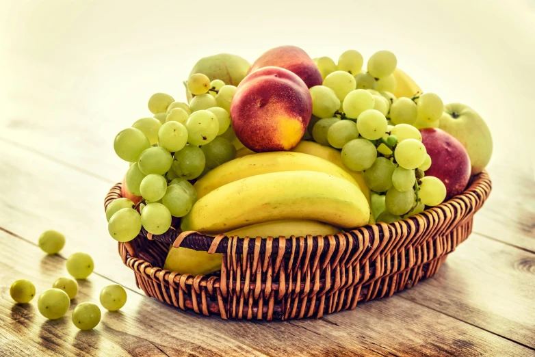 a basket of fruit sitting on top of a wooden table, profile image, yellow and green, local foods, facing the camera