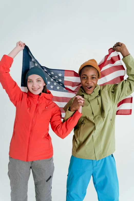 a couple of people standing next to each other holding an american flag, wearing adventure gear, sports jacket, kids, profile image