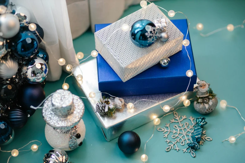 a pile of presents sitting on top of a table, blue and silver, string lights, thumbnail, silver accessories