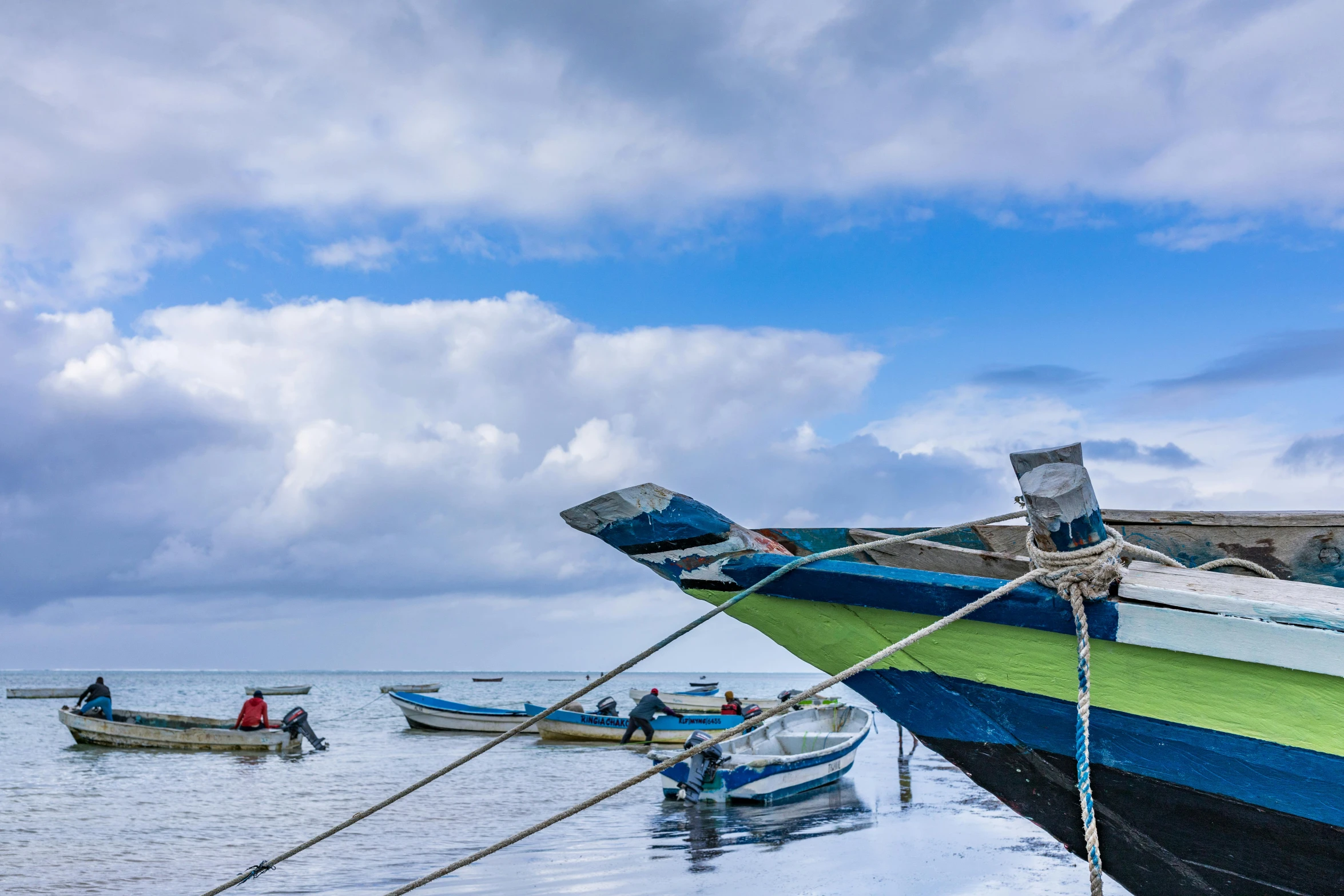 a group of boats sitting on top of a body of water, by Jessie Algie, pexels contest winner, hurufiyya, mami wata, under blue clouds, thumbnail, coloured photo