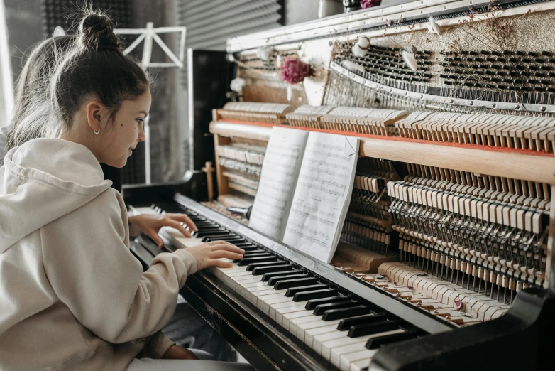 a girl playing the piano in a music studio, by Everett Warner, pexels contest winner, lachlan bailey, school class, profile image, multiple stories